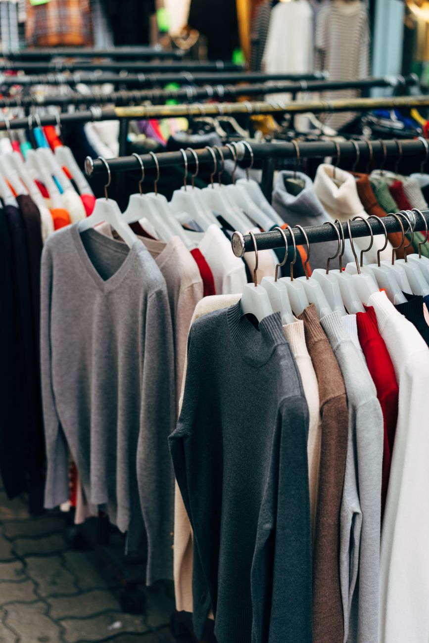 Une collection de vêtements colorés sur des étagères dans un magasin de détail.